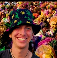 a man wearing a colorful hat in front of a crowd of people