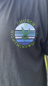 a man wearing a t - shirt that says church of highknowledge