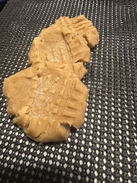 two pieces of peanut butter cookies sitting on top of a metal tray