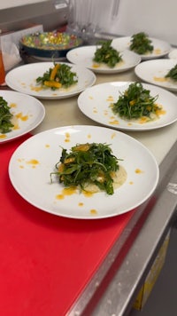 a plate of arugula salad on a counter